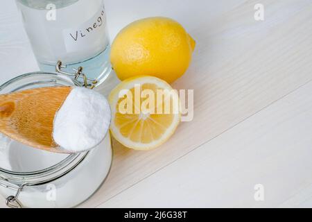 Aprire il vaso di bicarbonato con un cucchiaio di legno sulla parte superiore, aceto, limone tagliato. Vista dall'alto, spazio per il testo. Il concetto di rimozione organica macchie sui vestiti. H Foto Stock