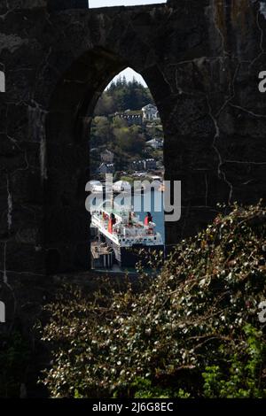 Città portuale scozzese vista attraverso un arco di pietra con traghetto e case costiere Foto Stock