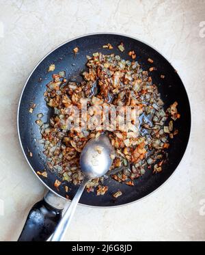 Frittura di cipolle in padella isolata su fondo bianco Foto Stock