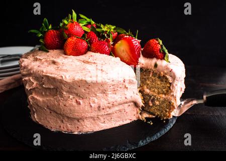 Torta di fragole a fette con fragole fresche: Vista laterale della torta di fragole fresca con glassa di formaggio cremoso Foto Stock