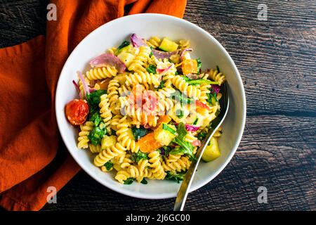 Pasta arrosto di Veggie Fusilli con Feta in una ciotola poco profonda: Rotini si torce con verdure arrostite in una salsa di formaggio feta Foto Stock