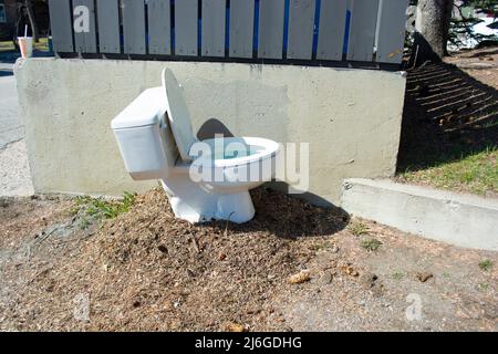 La ciotola della toilette si trova all'esterno accanto all'area spazzatura. Foto Stock