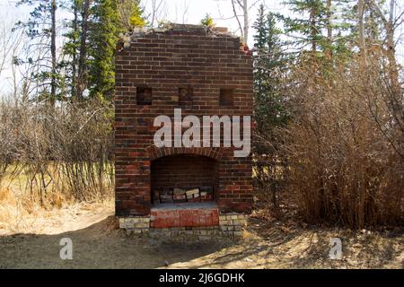 Old Brick Camino rimane nei boschi da un Old Ranch House. Foto Stock