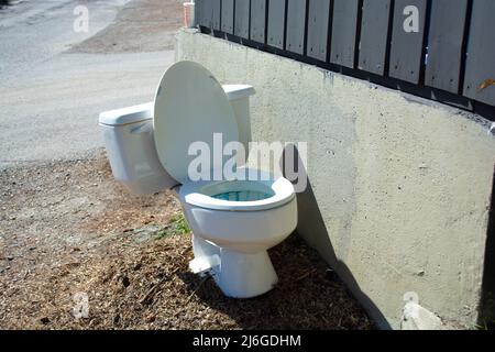 La ciotola della toilette si trova all'esterno accanto all'area spazzatura. Foto Stock