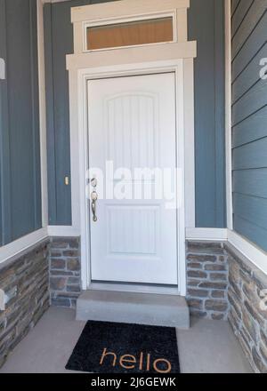 Verticale porta anteriore esterno di una casa con pareti laterali in legno e mattoni in pietra Foto Stock