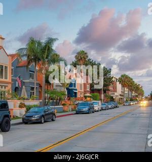 Nuvole piazza Puffy al Sunset Road nel mezzo degli edifici residenziali con vehi parcheggiato Foto Stock