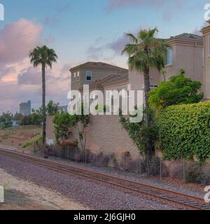 Piazza nuvole Puffy al tramonto treno singolo fuori dalla zona residenziale di Oceanside, Foto Stock