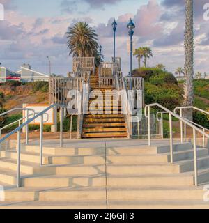 Piazza nuvole Puffy al tramonto Scale all'aperto con gradini in cemento e legno a Oceanside, Cali Foto Stock