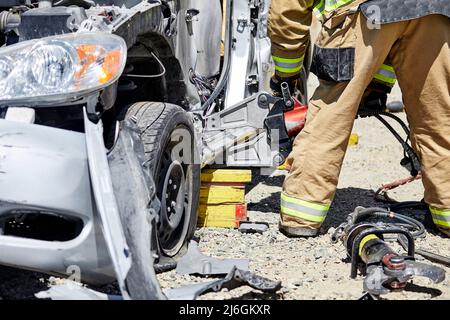 Vigili del fuoco che utilizzano le JAWS of Life per smontare un'auto durante una dimostrazione Foto Stock