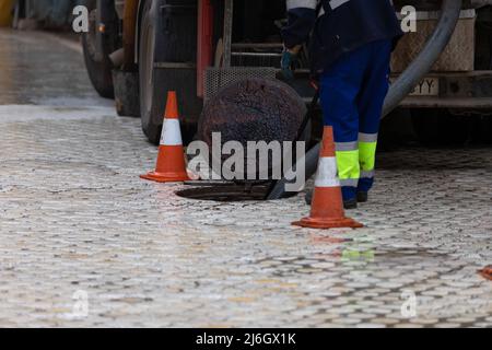 Scarico pulizia, scarico del carrello di scarico che pompa acqua contaminata Foto Stock