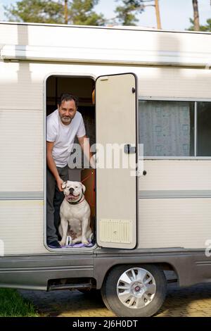 il concetto di viaggiare in un camper. uomo che viaggia con il cane Foto Stock