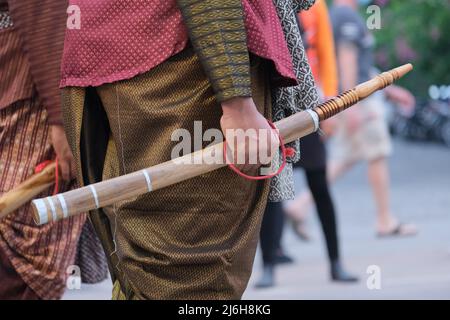 Un uomo tailandese indossa un abito tradizionale e tiene una spada tradizionale (daab) su una sfilata Foto Stock