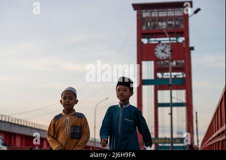 (220502) -- GIACARTA, 2 maggio 2022 (Xinhua) -- i bambini attraversano il ponte di Ampera per assistere alle preghiere di Eid al-Fitr a Palembang di Sumatra del Sud, Indonesia, il 2 maggio 2022. (Xinhua/veri Sanovri) Foto Stock