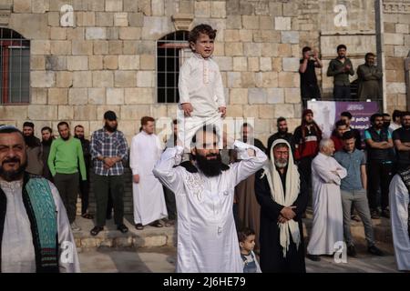 02 maggio 2022, Siria, Idlib: I musulmani siriani stanno di fronte ad una moschea nella città di Idlib dopo aver eseguito la preghiera di Eid al-Fitr. Foto: ANAS Alkharboutli/dpa Foto Stock