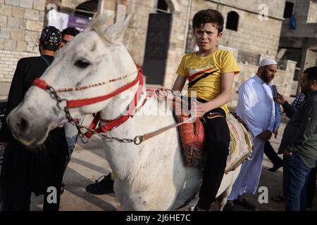 02 maggio 2022, Siria, Idlib: Un bambino siriano corre un cavallo il primo giorno di Eid al-Fitr nella città di Idlib. Foto: ANAS Alkharboutli/dpa Foto Stock