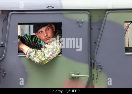 Soldato che sbucciava dal finestrino del suo veicolo. Parata militare a Bruxelles. Foto Stock