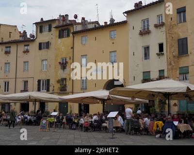 La gente cena in ristoranti nel vecchio anfiteatro romano, Piazza dell'Anfiteatro, Lucca, Toscana, Italia, Europa Foto Stock