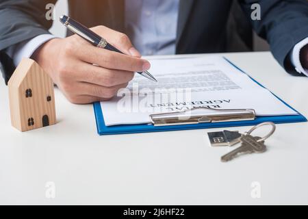 uomo che firma i documenti di contratto di casa. Contratto di contratto, immobiliare, acquisto e vendita e concetti assicurativi Foto Stock