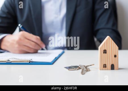 uomo che firma i documenti di contratto di casa. Contratto di contratto, immobiliare, acquisto e vendita e concetti assicurativi Foto Stock