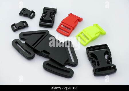 Fibbia universale per cinture di sicurezza a cinque punti per passeggini, seggioloni. Bulloneria in plastica per il fissaggio di cinghie e spalline. fas nero, rosso, giallo Foto Stock