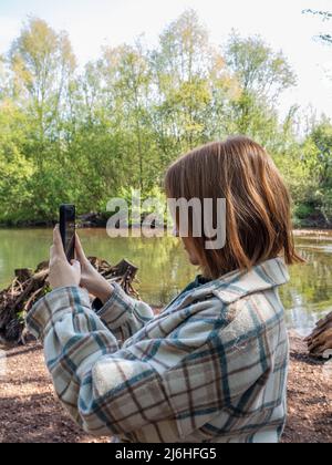 giovane donna che cerca di ottenere un segnale di cellulare in campagna Foto Stock