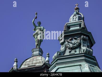 02 maggio 2022, Sassonia, Lipsia: La scultura in bronzo "la verità" corona la cupola del Tribunale amministrativo federale. Il Tribunale federale si occupa dei casi di due funzionari della Bundeswehr che rifiutano di essere vaccinati contro il coronavirus. Il Ministero della Difesa aveva incluso la vaccinazione del Covid-19 come obbligatoria a partire dal 24 novembre 2021. I due uomini invocano il loro diritto fondamentale all'integrità fisica e hanno presentato ricorso contro di esso. Foto: Jan Woitas/dpa Foto Stock