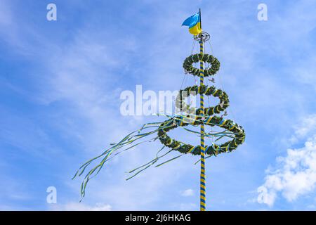 Maypole con nastri giallo-azzurri e colombe bianche come simbolo di solidarietà con l'Ucraina, cielo blu con nuvole a Lubeck, Germania, Foto Stock