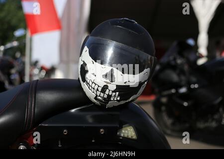 Un casco con un modello di cranio sulla motocicletta Foto Stock