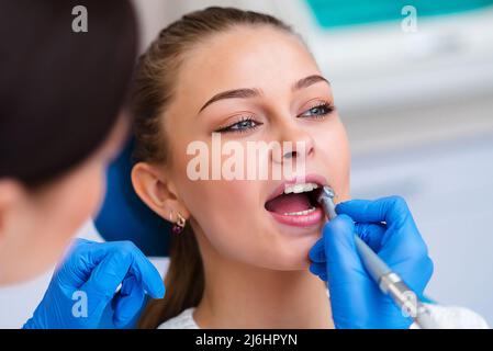 Medico che esamina i denti del paziente, primo piano. Odontoiatria cosmetica Foto Stock