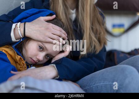 Depressi immigrati ucraini seduti e in attesa alla stazione ferroviaria. Foto Stock