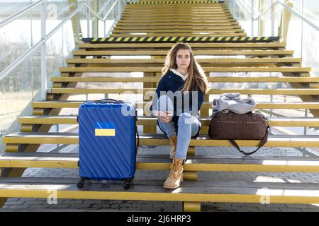 Depressa immigrata Ucraina giovane donna seduta e in attesa alla stazione ferroviaria. Foto Stock