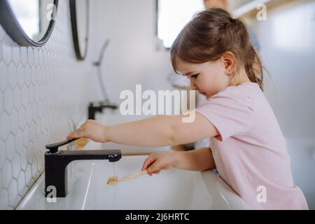 Bambina spazzolando i denti in bagno, mattina concetto di routine. Foto Stock