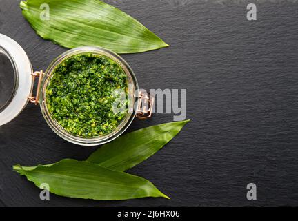 Salsa di pesto fatta in casa con foglie di Allium ursinum, noto come aglio selvatico, ramsons, buckrams, aglio a foglia larga, aglio di legno, porro. Foto Stock