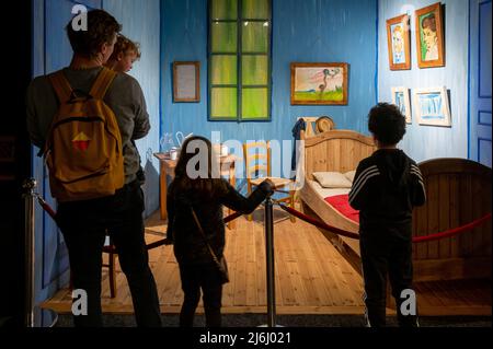 London Shoreditch, Regno Unito. 30 aprile 2022. Famiglia con bambini di fronte alla replica di Bedroom in Arles a Van Gogh la mostra immersive Experience Foto Stock