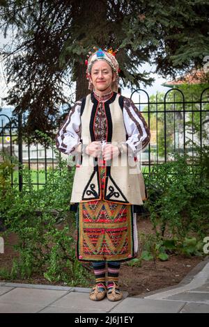 Seslavtsi, Bulgaria, 30 aprile 2022: Una donna in costume folcloristico tradizionale in Bulgaria. Autentico costume di cento anni fr Foto Stock