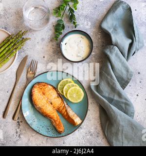 Fresche alla griglia filetto di salmone con spezie e gli asparagi in piastra di blu. Immagine quadrata per la ricetta culinaria Foto Stock