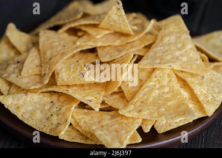 Il più famoso snack messicano, nachos fatta con il mais tortilla chips o totopos su sfondo di legno. Close up Foto Stock