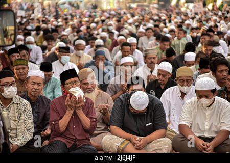 Gli uomini musulmani offrono preghiere durante Eid 1443 Hijriyah / 2022 d.C. vicino ad una chiesa in Jatinegara. Quest'anno, il governo indonesiano ha permesso che le preghiere di Eid si tenevano insieme dopo due anni di cancellazione a causa della pandemia del Covid-19. (Foto di Risa Krisadhi / SOPA Images/Sipa USA) Foto Stock