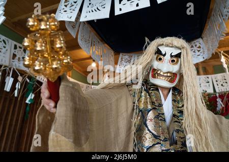 Fujisaki-san, un maestro della rappresentazione rituale di Kagura lo Shinto che racconta le stoires degli dei. Indossare la maschera bianca per eseguire la danza di Tajikar Foto Stock