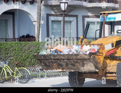 Primo piano di un bulldozer che trasporta rifiuti su una strada urbana in Messico Foto Stock