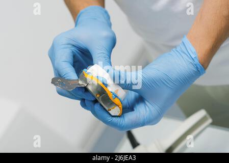 Il dentista fa un'impressione dei denti. Primo piano di un dentista in guanti blu Foto Stock