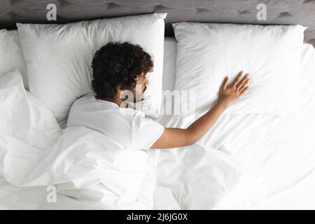 Vista dall'alto del ragazzo solitario che tocca il cuscino accanto a lui Foto Stock