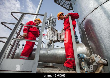 Regione di Kyzylorda, Kazakhstan, 01 maggio 2012: Due operatori petroliferi di impianti di raffineria e torri di distillazione Foto Stock