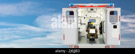 Vista posteriore dell'interno di un'ambulanza aperta di fronte a un cielo blu con spazio copia Foto Stock