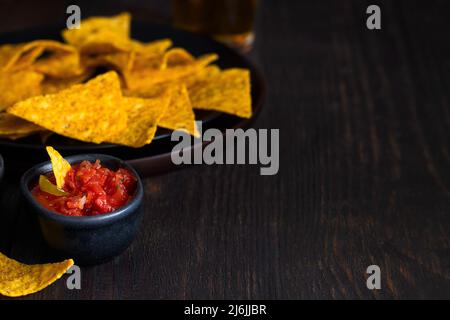 Salse al peperoncino rosso con nachos fatti con tortilla di mais sul tavolo. Totopos con salsa di avocado piatto messicano background.Copy spazio Foto Stock