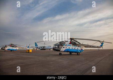 Aktau, Kazakhstan - 21 maggio 2012: Aeroporto internazionale di Aktau. Elicotteri sovietici e Antonov 124 cargo jet a terra. Bel cielo blu con nuvole. Foto Stock