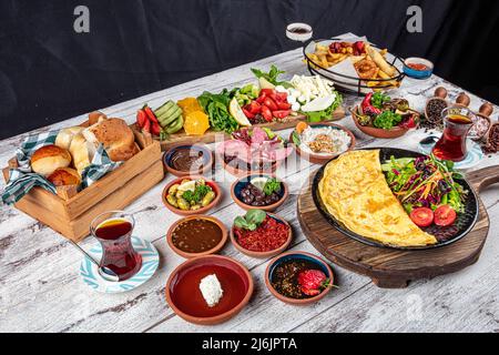 Tavolo per la colazione turco. Dolci, verdure, verdure, olive, formaggi, omelette, spezie, marmellate, miele, tè in thermos, composizione grande. Colazione Foto Stock