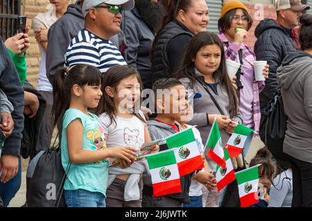 Detroit, Michigan USA - 1 maggio 2022 - i bambini hanno bandiere messicane mentre guardano la parata del Cinco de Mayo nel quartiere messicano-americano di Detroit. Migliaia di persone hanno assistito alla sfilata annuale, che è tornata nel 2022 dopo un periodo di due anni a causa della pandemia. Cinco de Mayo celebra la vittoria messicana sui francesi il 5 maggio 1862. Credit: Jim West/Alamy Live News Foto Stock