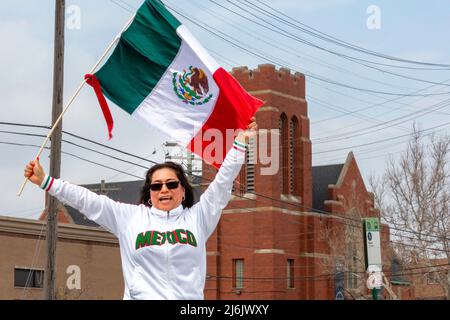 Detroit, Michigan USA - 1 maggio 2022 - Una donna svetta una bandiera messicana durante la parata Cinco de Mayo nel quartiere messicano-americano di Detroit. La sfilata annuale è tornata nel 2022 dopo un periodo di due anni a causa della pandemia. Cinco de Mayo celebra la vittoria messicana sui francesi il 5 maggio 1862. Credit: Jim West/Alamy Live News Foto Stock