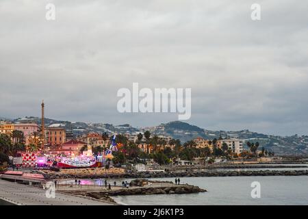 Vista panoramica della città costiera con il parco divertimenti sul lungomare al crepuscolo in inverno, Sanremo, Imperia, Liguria, Italia Foto Stock